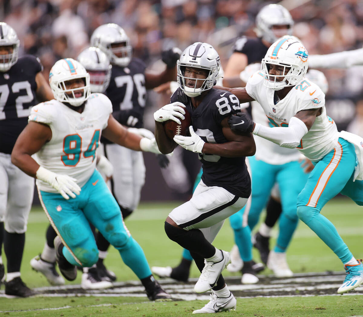 Las Vegas Raiders wide receiver Bryan Edwards (89) makes a catch as he gets tackled by Miami Do ...