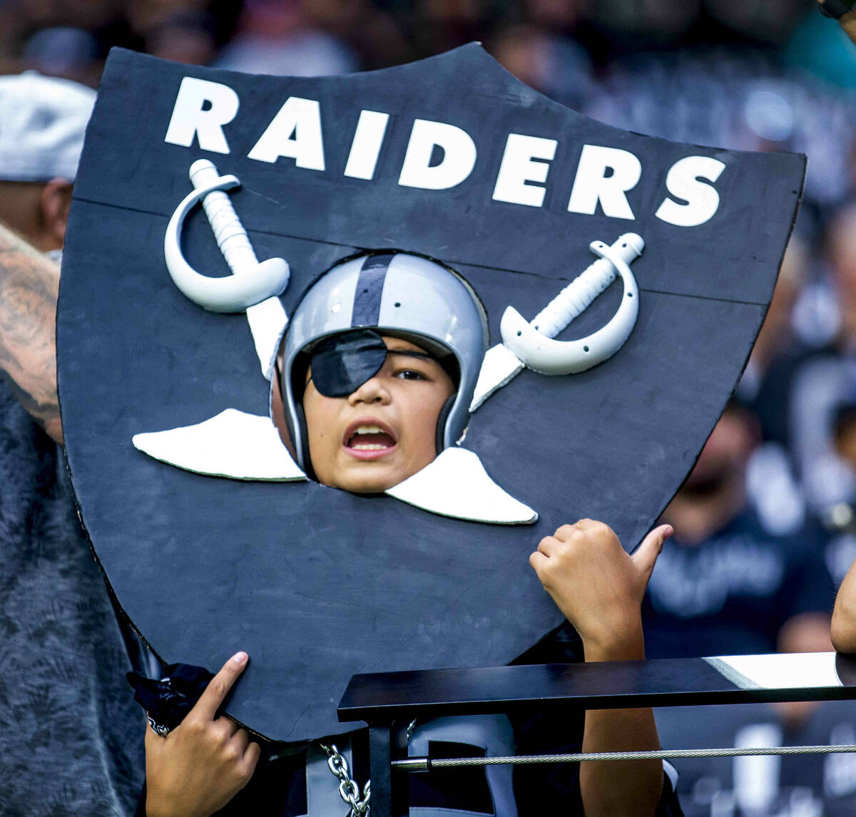 A young Raiders fan wears a homemade shield versus the Miami Dolphins in the first half of thei ...