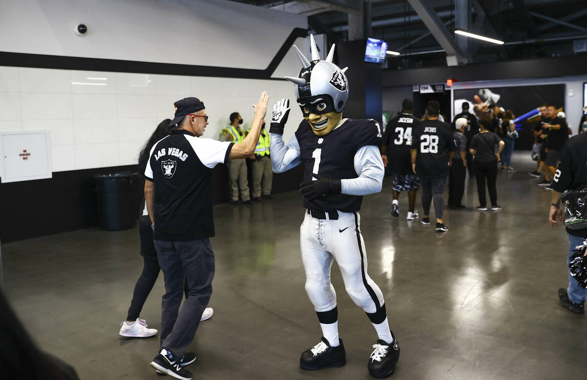 Mascot Raider Rusher greets fans as they arrive at Allegiant Stadium while tailgating before an ...