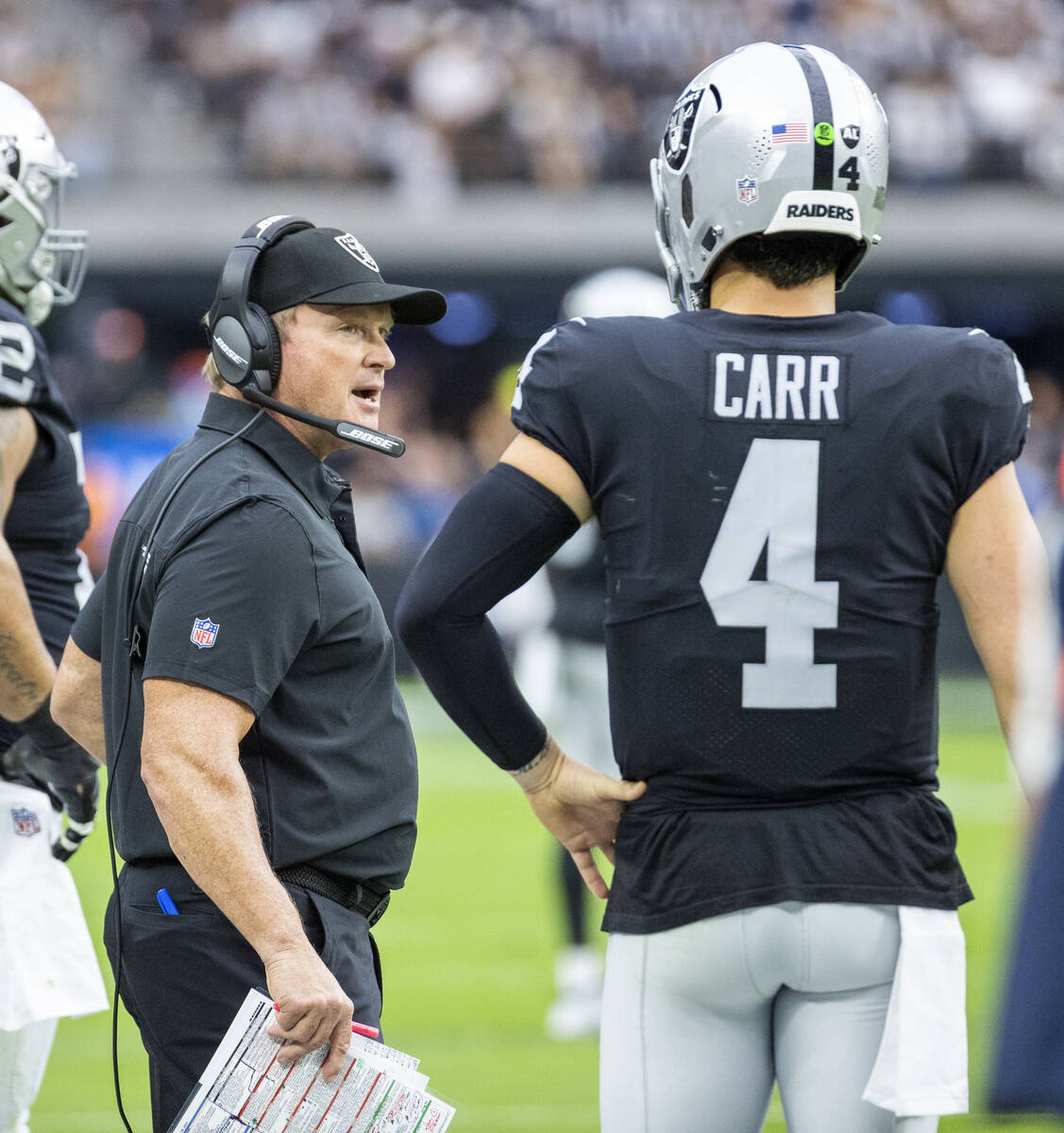 Raiders head coach Jon Gruden talks with quarterback Derek Carr (4) in the first half of their ...