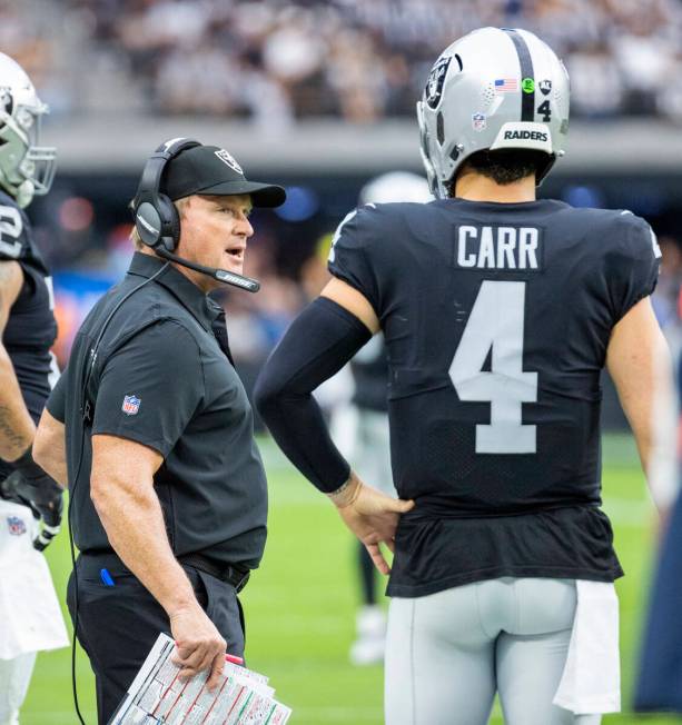 Raiders head coach Jon Gruden talks with quarterback Derek Carr (4) in the first half of their ...