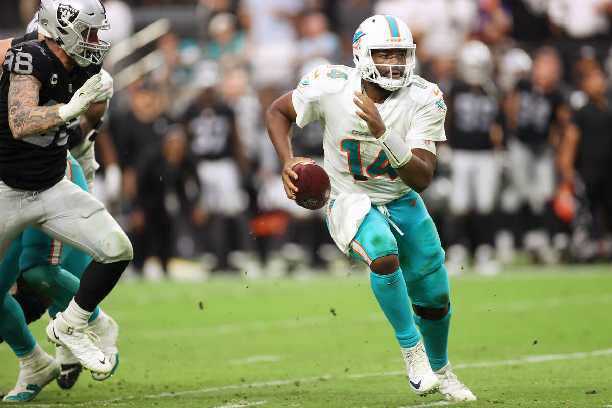 Miami Dolphins quarterback Jacoby Brissett (14) runs for a touchdown under pressure from Las Ve ...