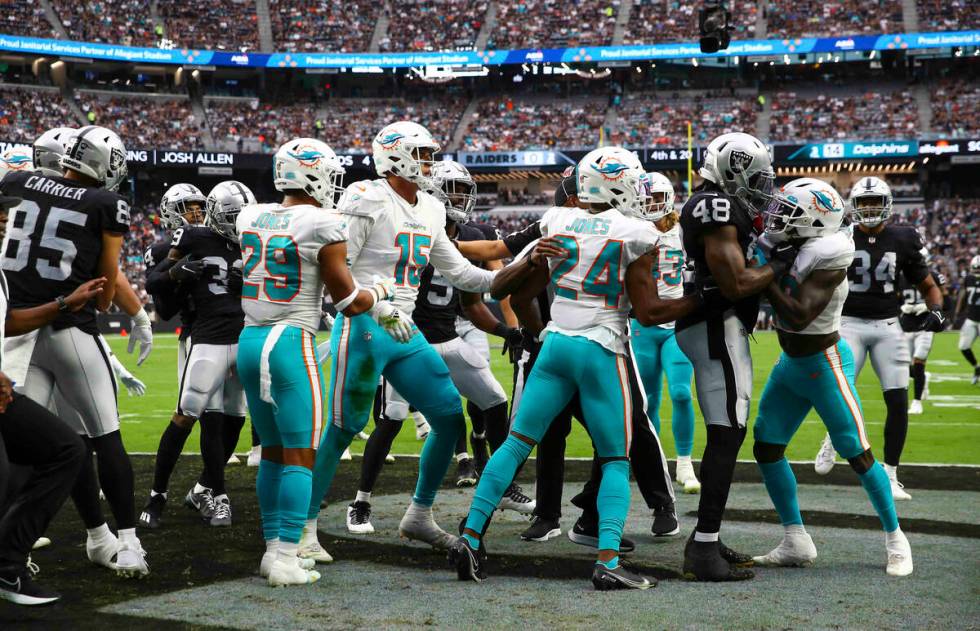 Referees try to break up the Miami Dolphins and Raiders during the first half of NFL game at Al ...