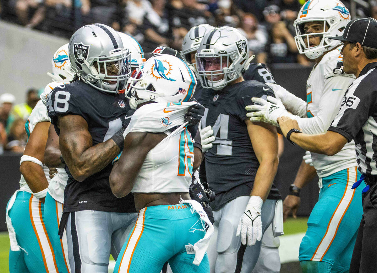 Raiders (48) gets in a fight in the end zone with Miami Dolphins wide receiver Jakeem Grant (19 ...