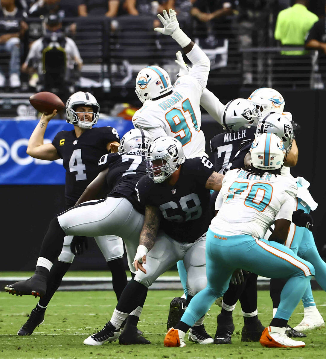 Raiders quarterback Derek Carr (4) looks to throw a pass under pressure from the Miami Dolphins ...