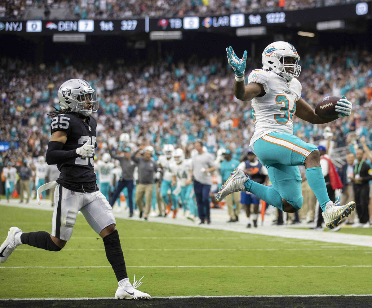 Miami Dolphins running back Malcolm Brown (34) leaps into the end zone past Las Vegas Raiders s ...