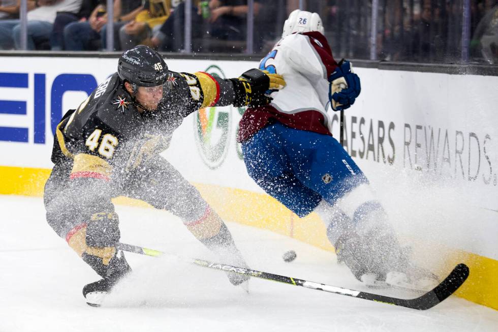 Golden Knights right wing Jonas Rondbjerg (46) and Avalanche defenseman Jacob MacDonald (26) co ...