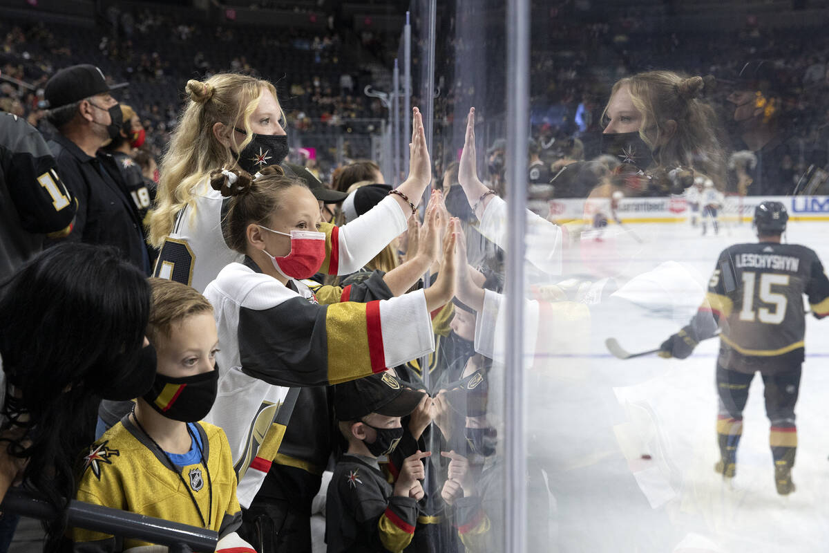 Young fans cheer for the Golden Knights during warmups as forward Jake Leschyshyn (15) skates p ...