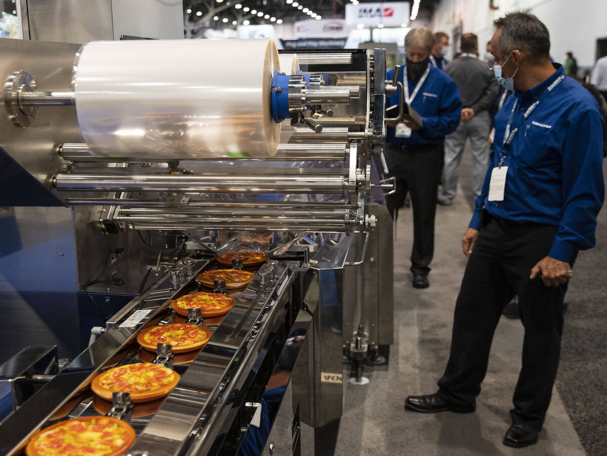 Artturo Bravo Cortes of Fuji Corp., right, operates Flow Wrapper during the PACK EXPO at the La ...