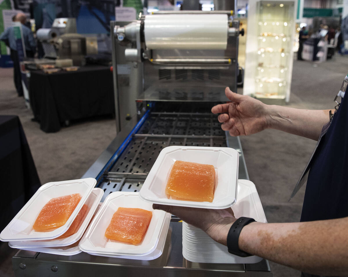 Brian Guillaume, left, of ProMach, holds pieces of salmon as he talks about ReeEco, an automati ...