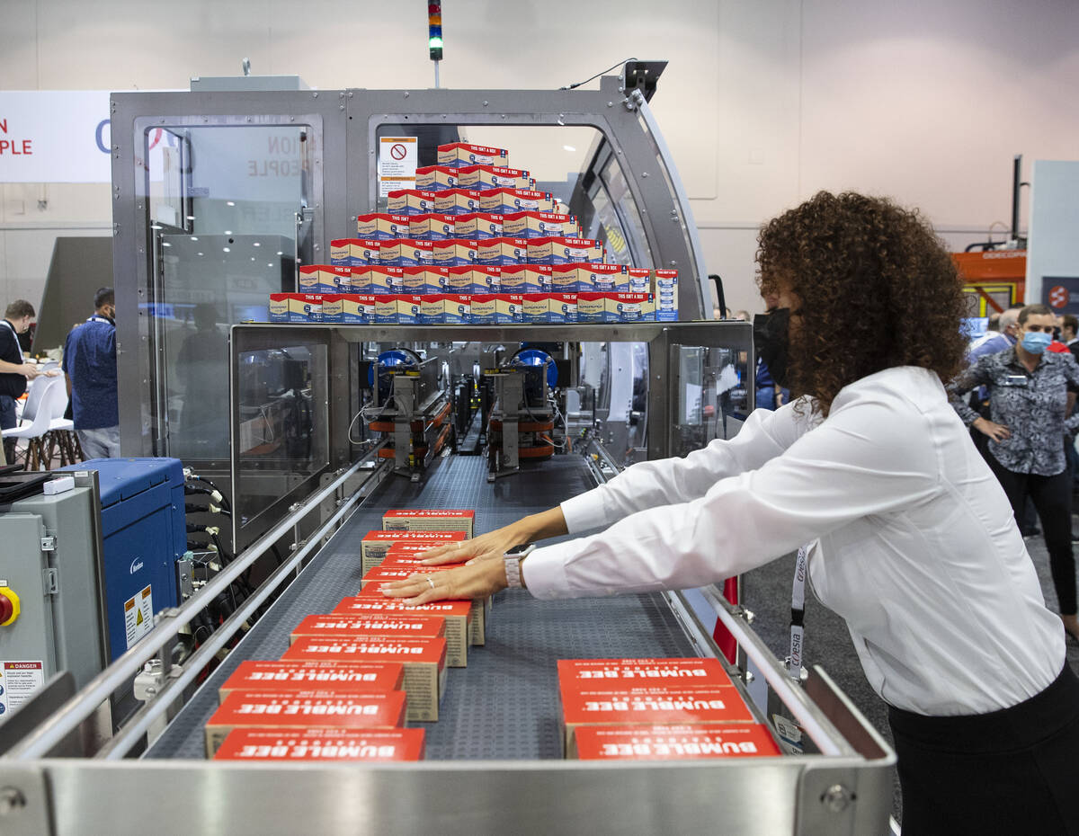 Crystal Gardner arranges the finished products from a Meridian XR MPS-30, beverage multi-pack c ...