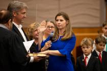 Judge Veronica Barisich is sworn in by Honorable Michael Cherry, while standing with her husban ...