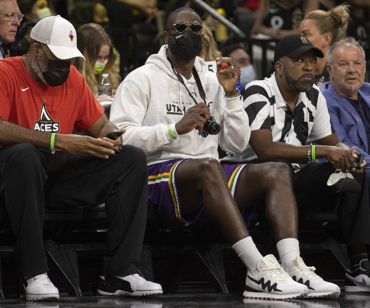 NBA legend Dwyane Wade, middle, takes in the action between the Las Vegas Aces and Phoenix Merc ...