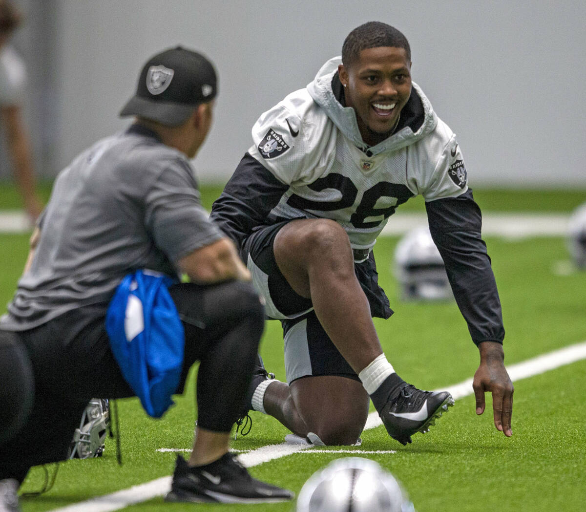 Raiders running back Josh Jacobs (28) laughs while stretching during a practice session at the ...