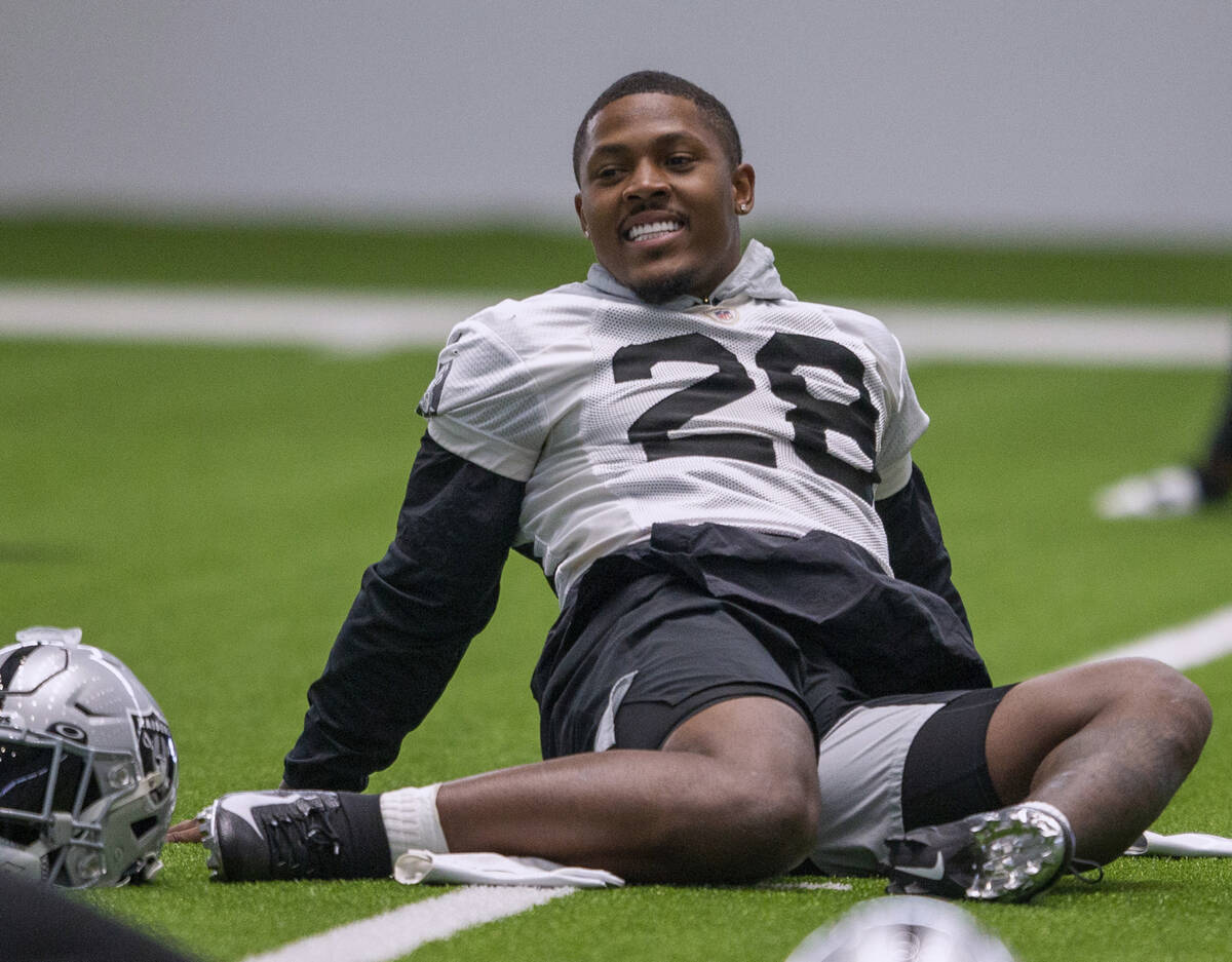 Raiders running back Josh Jacobs (28) laughs while stretching during a practice session at the ...