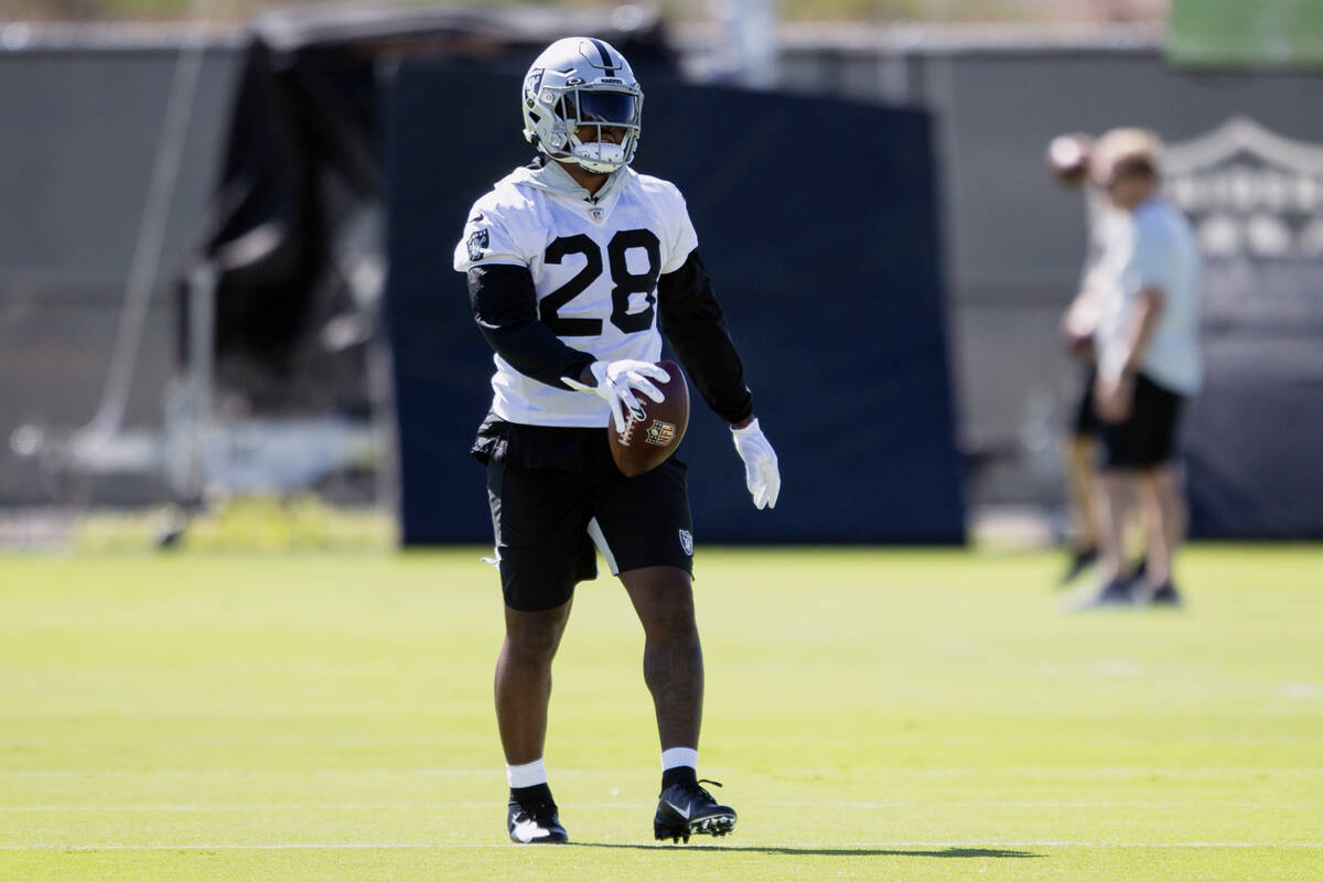 Raiders running back Josh Jacobs (28) walks on the field after a run during a practice session ...