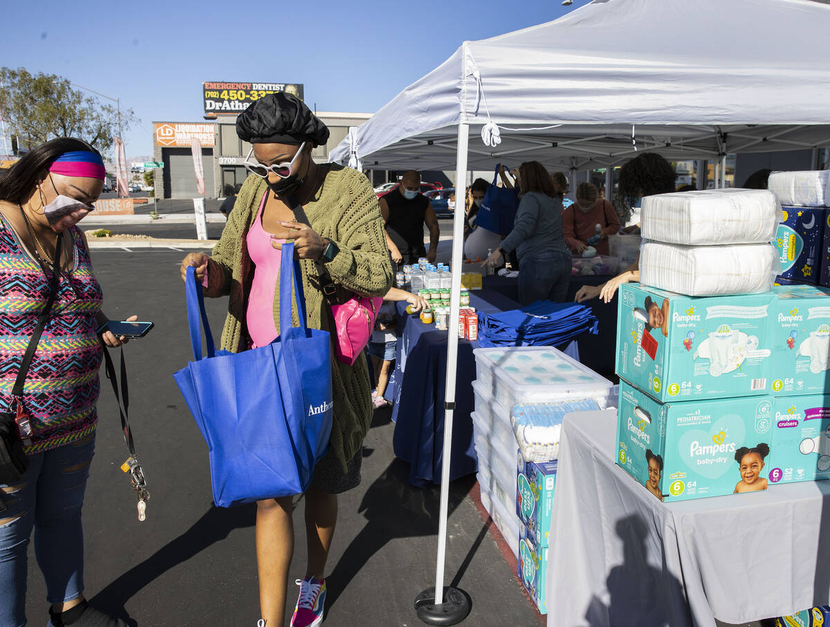 Shaun Evans, right, checks out her bag after receiving diapers during a pop-up diaper bank even ...
