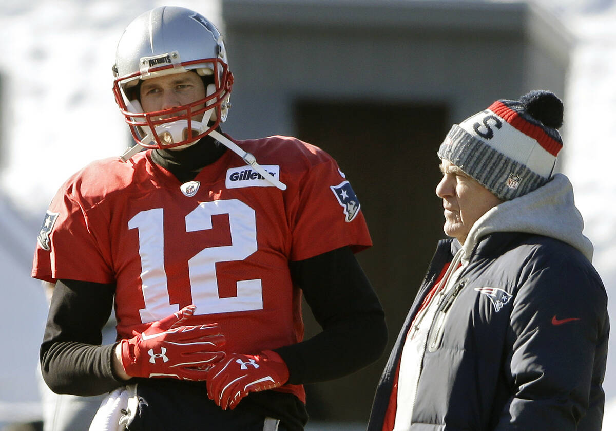 New England Patriots quarterback Tom Brady, left, stands with head coach Bill Belichick, right, ...