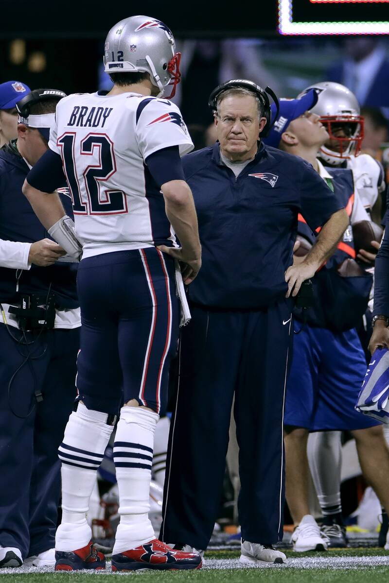 New England Patriots' Tom Brady, left, talks with head coach Bill Belichick during the first ha ...