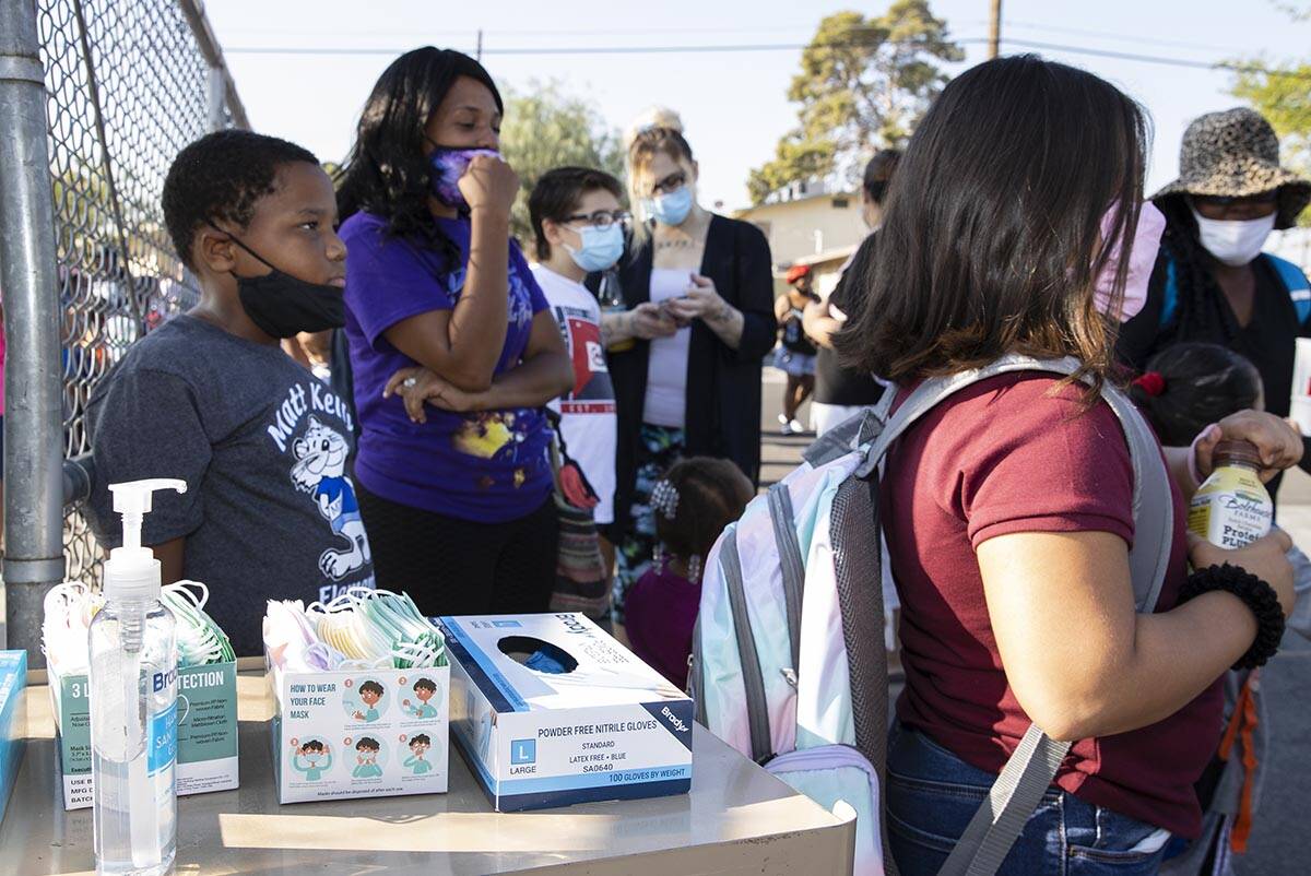 Hand sanitizer and face masks are displayed outside of Kelly Elementary Community School as stu ...