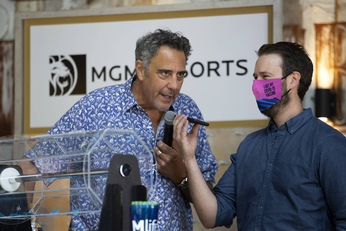 Comedian Brad Garrett, left, announces one of the raffle winners during a pop-up vaccination cl ...