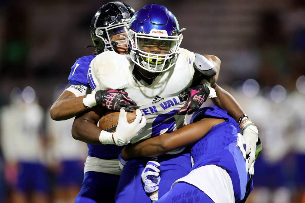 Desert Pines' Damari Washington (21) and Ferrari Busby (7) tackle Green Valley's Jaylen McKnig ...