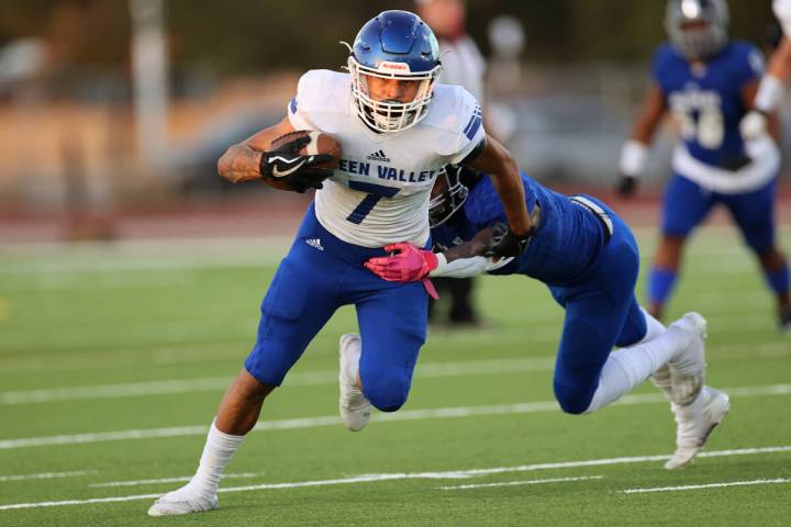 Green Valley's Anton Keeling (7) dodges a tackle by Desert Pines' Tyree Beasley (1) in the firs ...