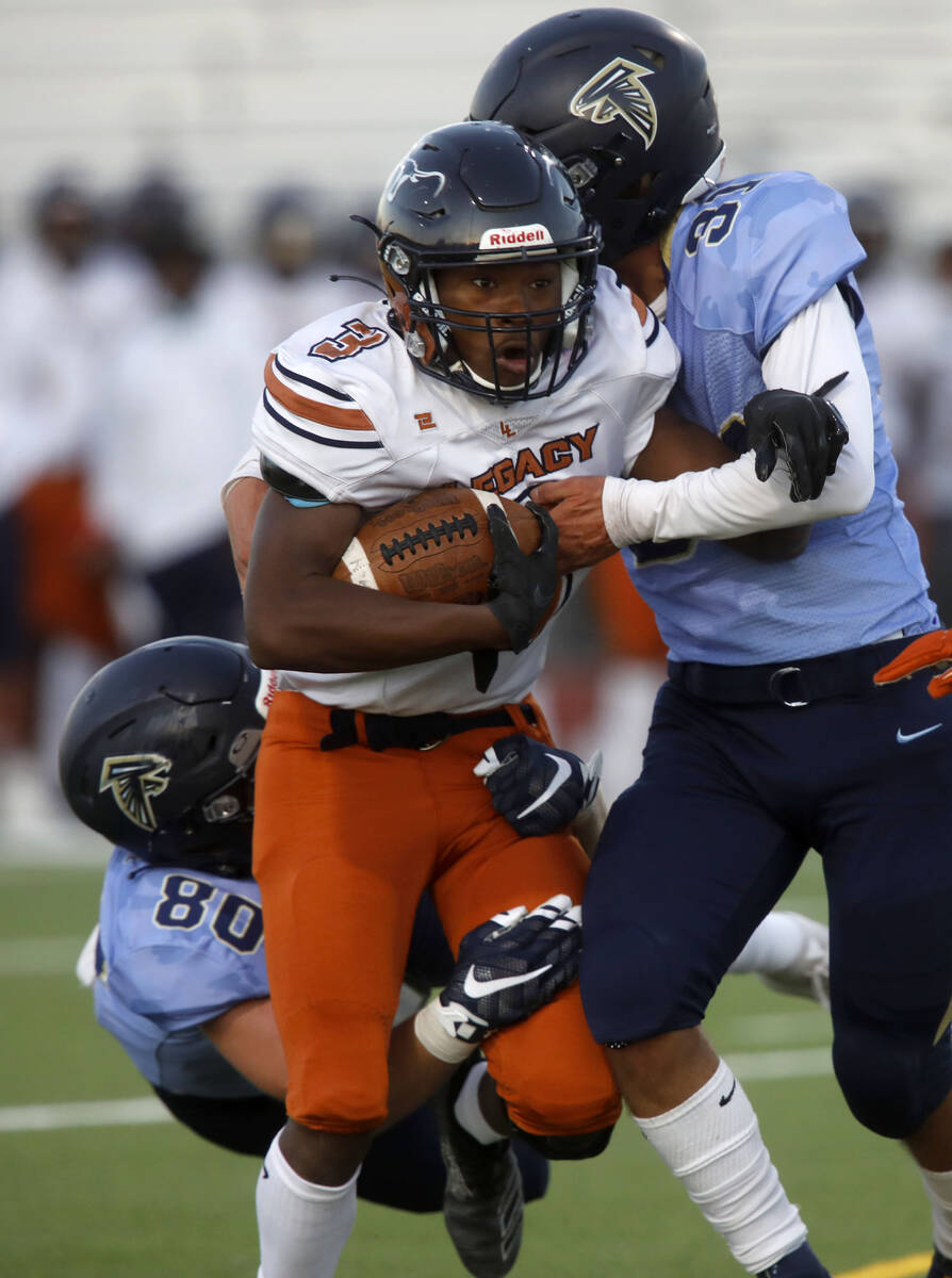 Legacy High School's Khalon White (3) is tackled by Foothill High School's Max Gardner (80) and ...
