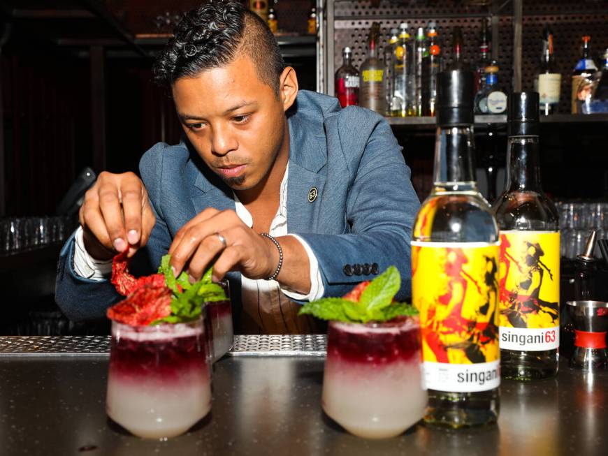 Ricky Lin, director of sales for Singani 63, left, creates the cocktail ÒSerenadeÓ&#x ...