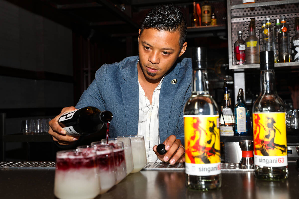 Ricky Lin, director of sales for Singani 63, left, creates the cocktail ÒSerenadeÓ&#x ...