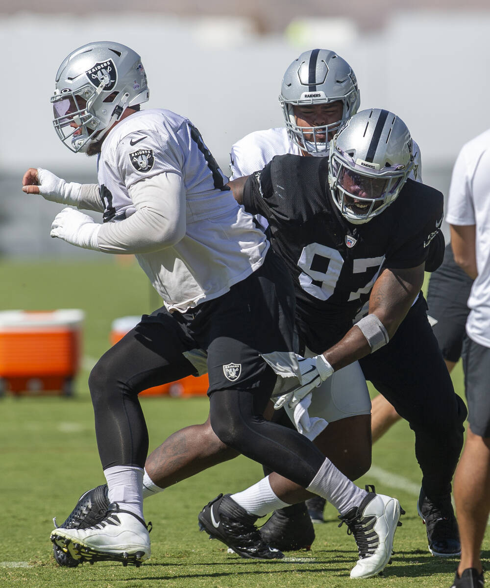 Raiders defensive end Damion Square (97) tries to wrap up Raiders center Andre James (68) durin ...