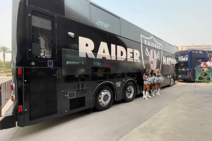 Three Raiderettes stand in front of RTC bus decked out in a Raiders wrap that is part of the RT ...