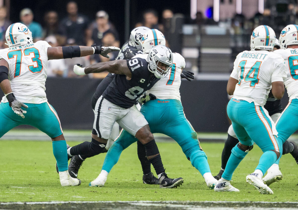 Raiders defensive end Yannick Ngakoue (91) busts through the Miami Dolphins offensive line duri ...