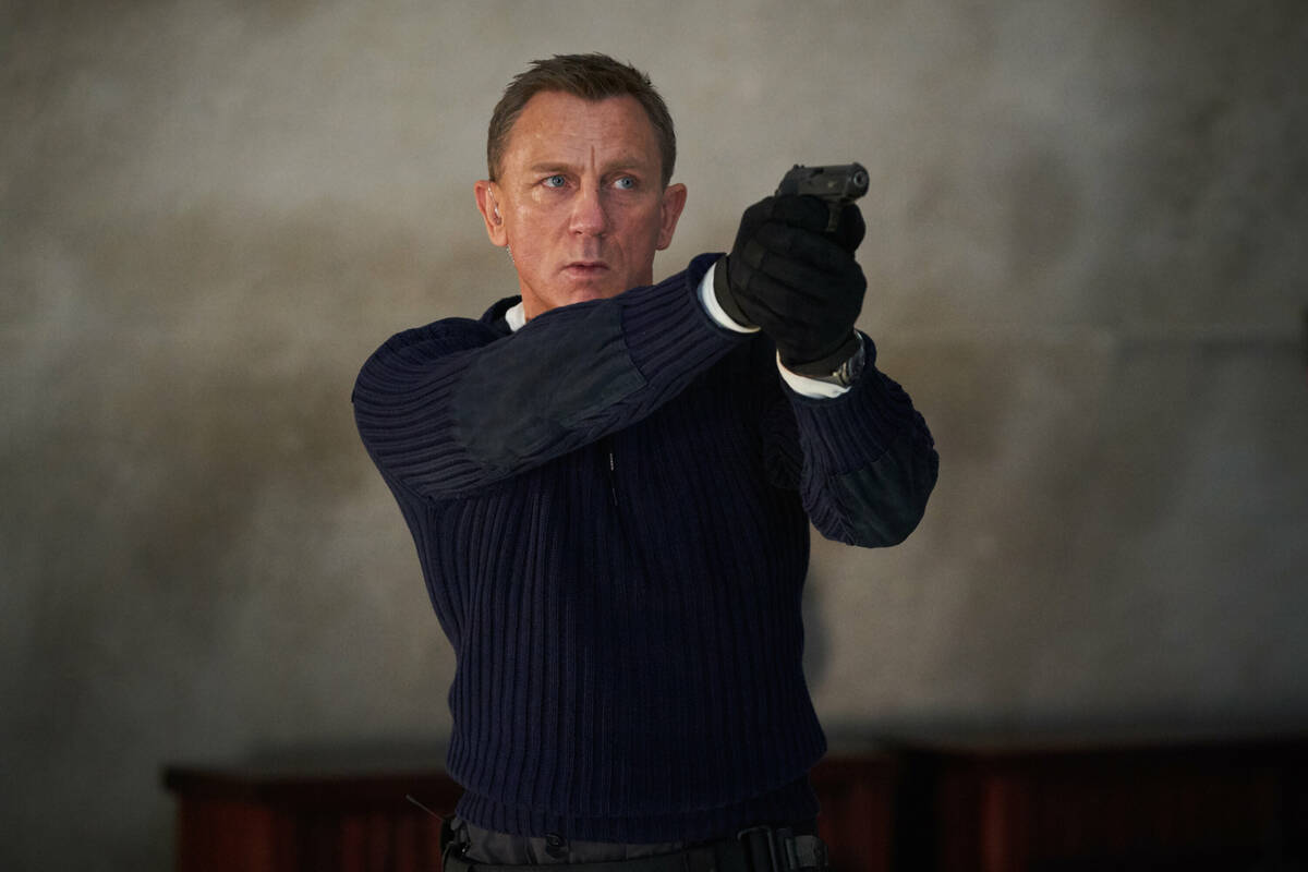 James Bond (Daniel Craig) prepares to shoot in "No Time to Die," an EON Productions and Metro-G ...