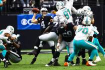 Raiders quarterback Derek Carr (4) looks to throw a pass under pressure from the Miami Dolphins ...