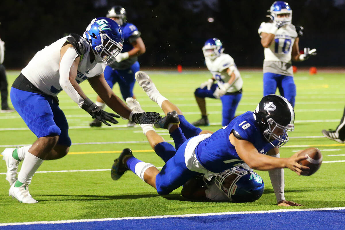 Desert Pines' quarterback Eddie Sandoval (18) dives for a touchdown in the first half of a foot ...