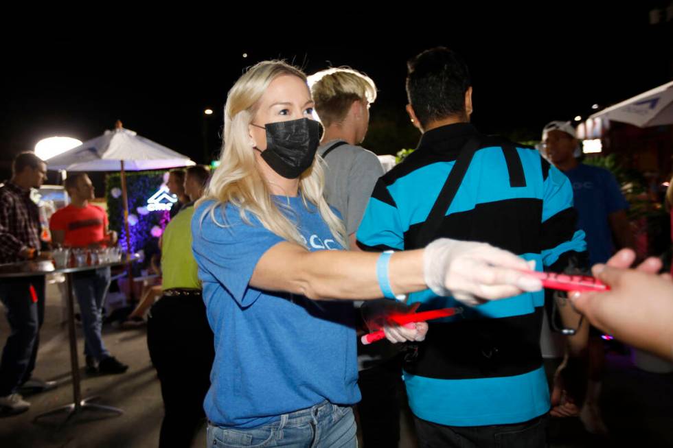 Lindsay Kilburn of MKTG and First Friday Foundation gives glow sticks before a moment of silenc ...