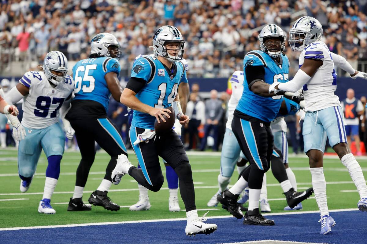 Carolina Panthers quarterback Sam Darnold (14) runs the ball for a touchdown as guard Dennis Da ...