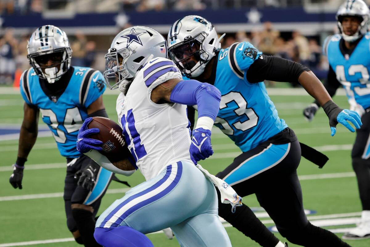 Dallas Cowboys' Ezekiel Elliott (21) gains yardage after a catch as Carolina Panthers' Sean Cha ...