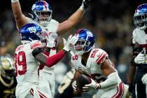 New York Giants running back Saquon Barkley (26) celebrates his touchdown in overtime with wide ...