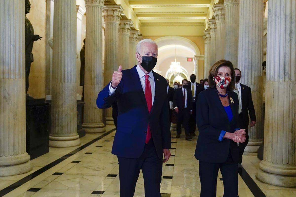 President Joe Biden gives a thumbs up as he walks with House Speaker Nancy Pelosi of Calif., on ...