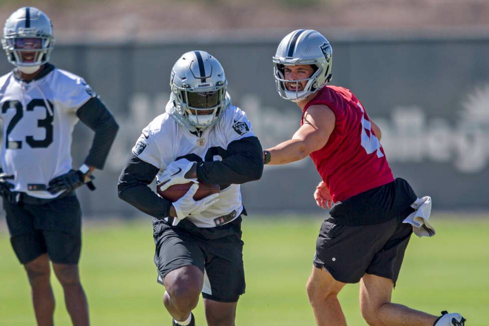 Raiders quarterback Derek Carr (4) hands the football off to Raiders running back Josh Jacobs ( ...