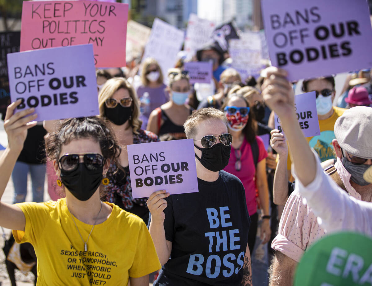 Demonstrators march down South Las Vegas Boulevard past the Lloyd D George Courthouse during a ...