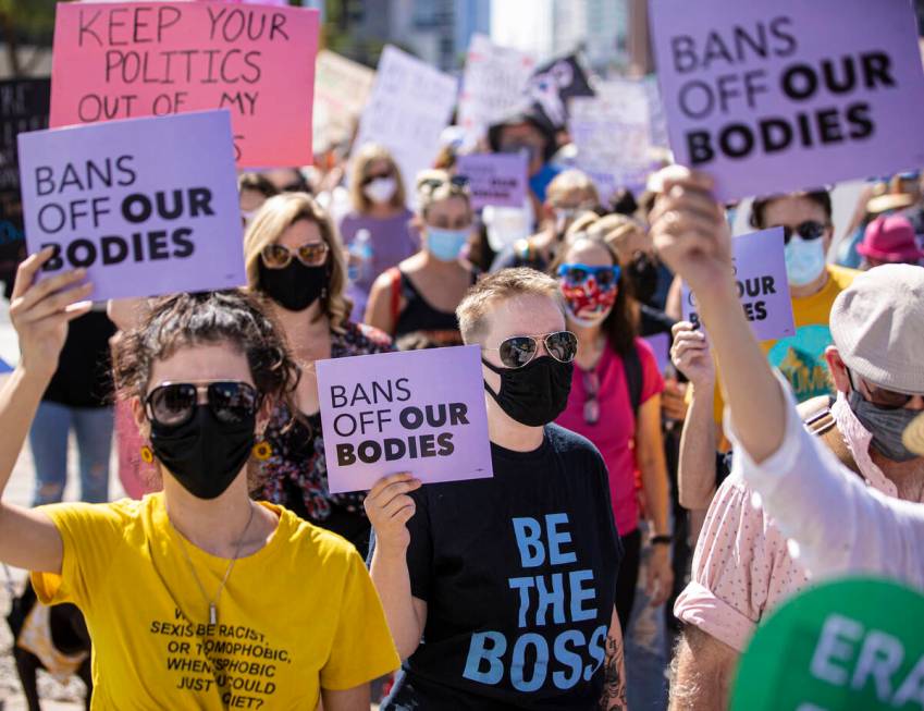 Demonstrators march down South Las Vegas Boulevard past the Lloyd D George Courthouse during a ...