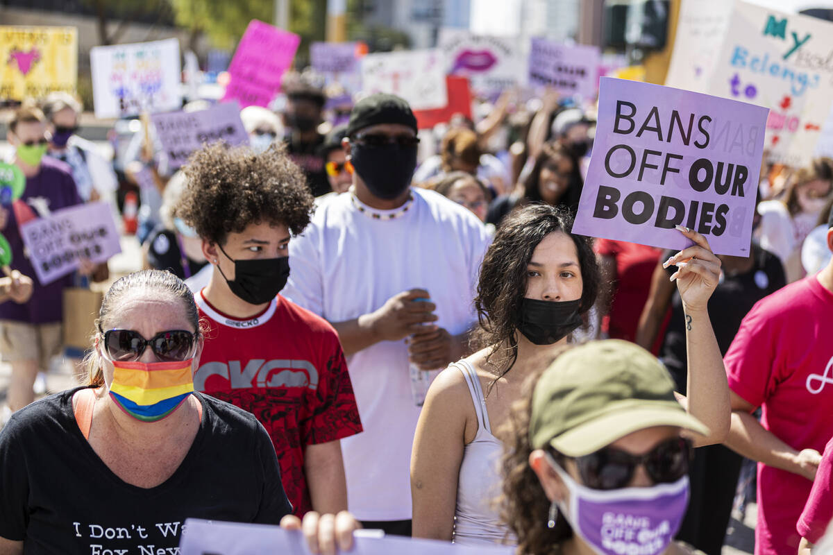 Demonstrators march down South Las Vegas Boulevard past the Lloyd D George Courthouse during a ...