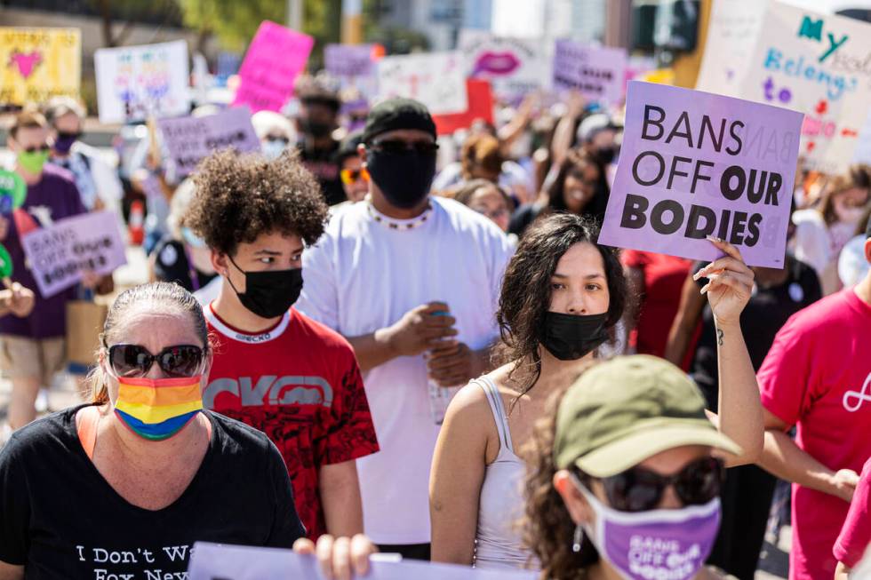 Demonstrators march down South Las Vegas Boulevard past the Lloyd D George Courthouse during a ...