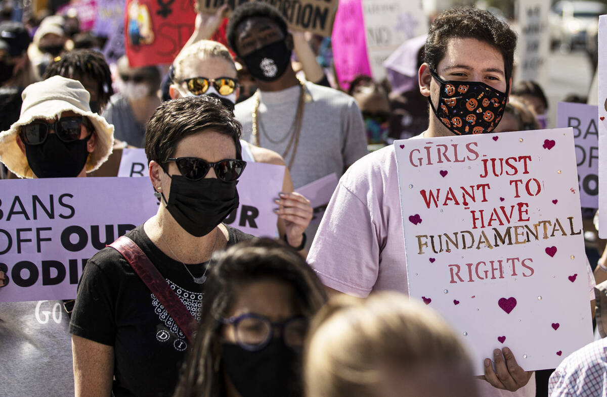 Demonstrators march down South Las Vegas Boulevard past the Lloyd D George Courthouse during a ...