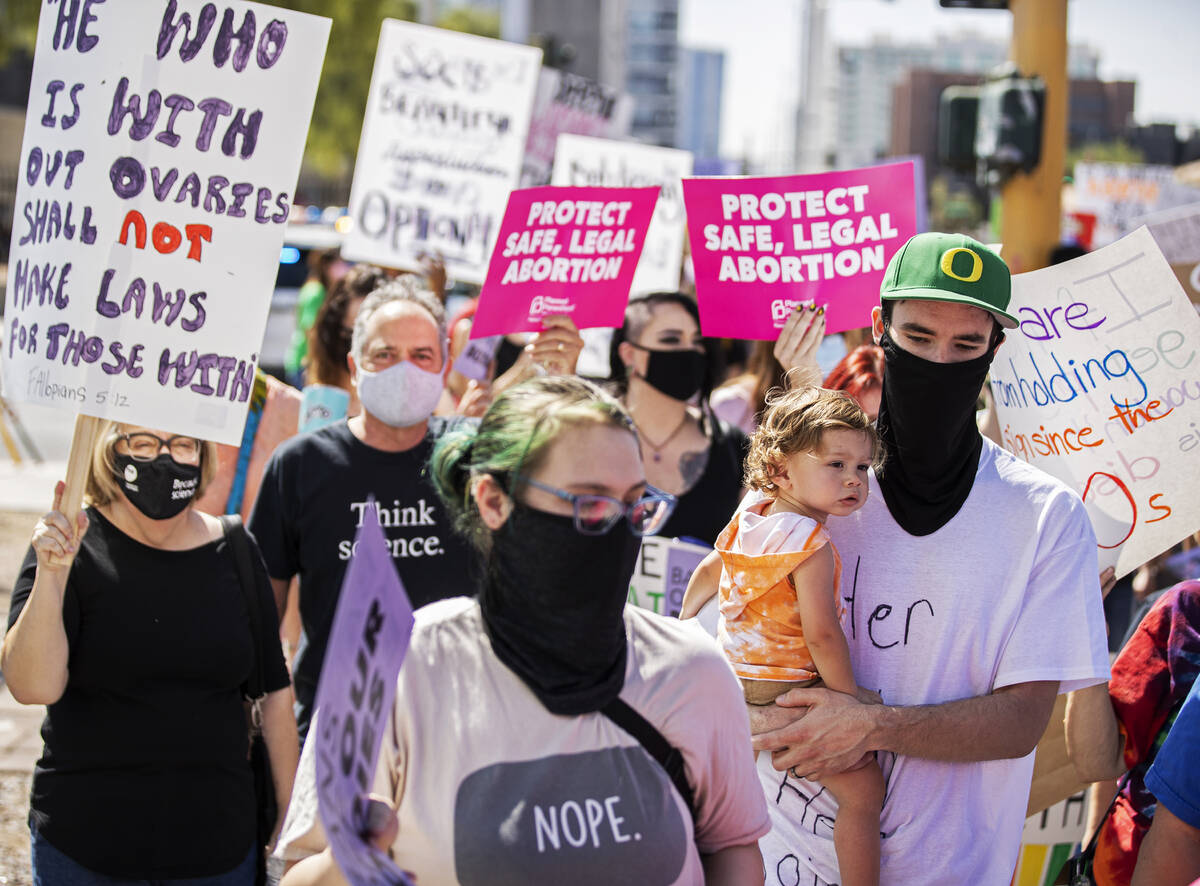 Demonstrators march down South Las Vegas Boulevard past the Lloyd D George Courthouse during a ...