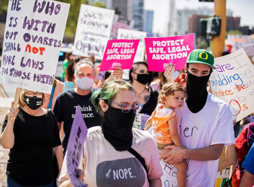 Demonstrators march down South Las Vegas Boulevard past the Lloyd D George Courthouse during a ...