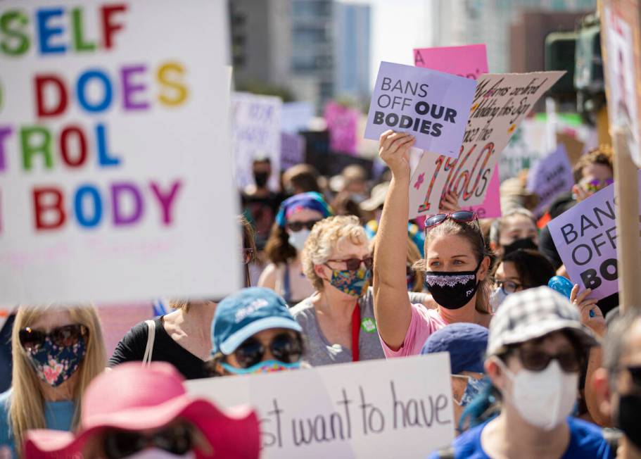 Demonstrators march down South Las Vegas Boulevard past the Lloyd D George Courthouse during a ...